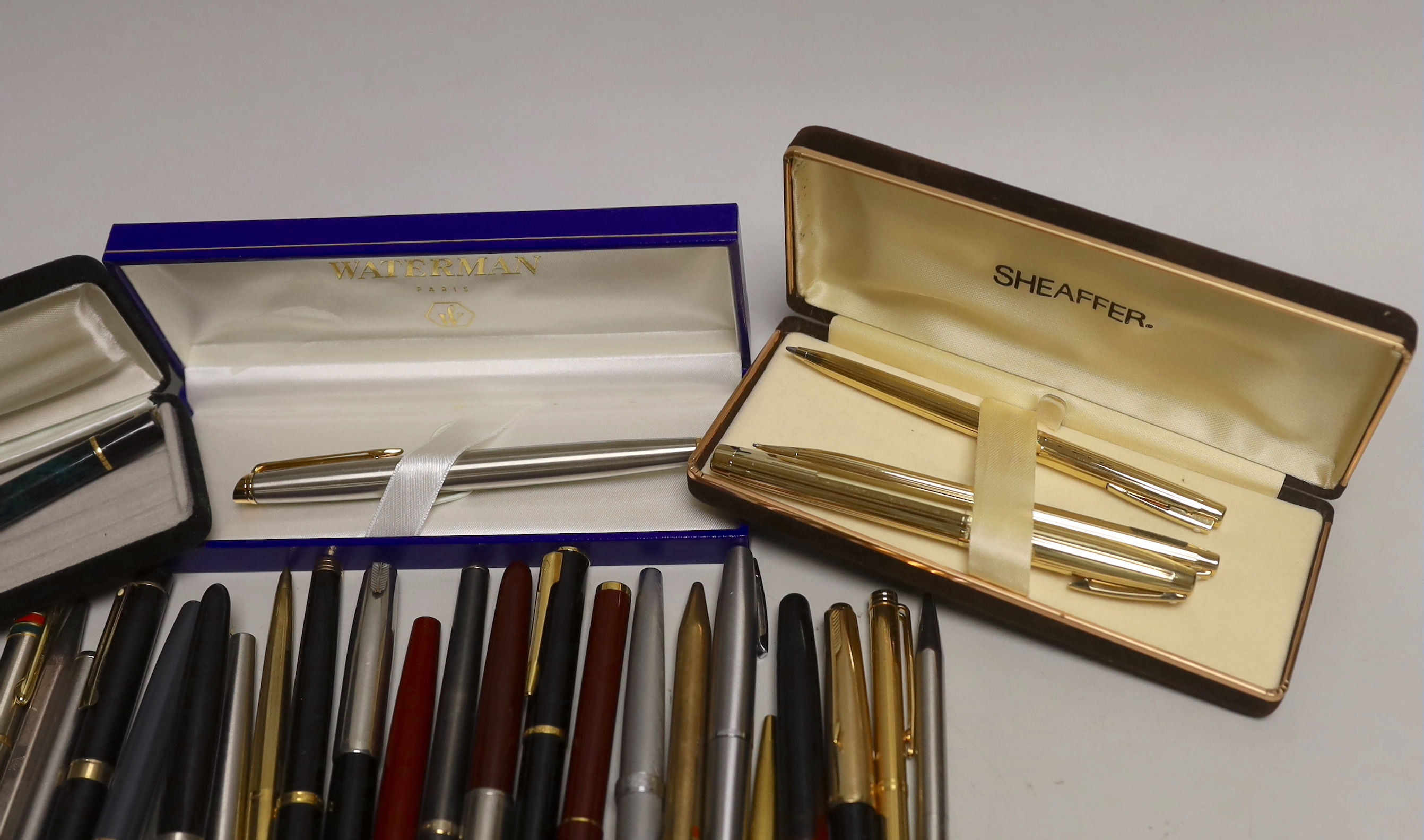 A group of fountain pens and ballpoint pens including a cased Sheaffer set